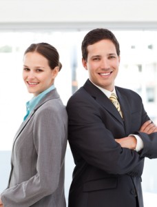 Happy businessman and businesswoman posing back to back